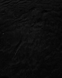 a black and white photo of water and sand